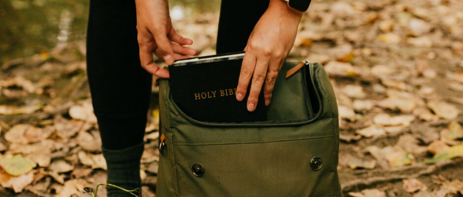 Girl putting bible in backpack